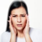 Woman shows post concussion syndrome symptoms like headaches and blurry vision