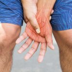 Hand suffering from peripheral neuropathy symptoms holds his left hand